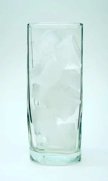 Cálice de vidro com gelo no fundo azul — Fotografia de Stock