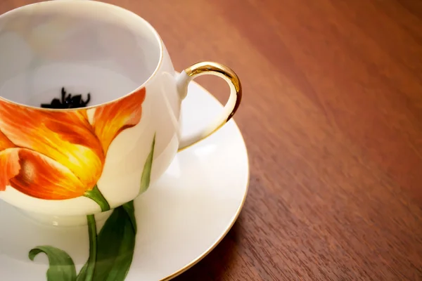 Teetasse und Untertasse aus Porzellan auf einem Holztisch — Stockfoto