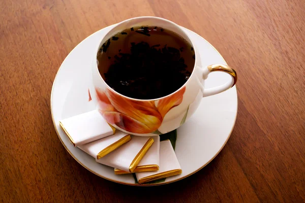 Porselen çay fincanı ve tabağı ahşap bir masa üzerinde — Stok fotoğraf