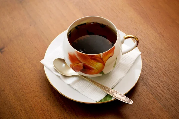 Porselen çay fincanı ve tabağı ahşap bir masa üzerinde — Stok fotoğraf