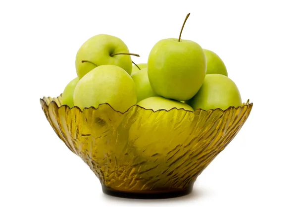 Зеленые яблоки в стеклянной вазе на скатерти — стоковое фото
