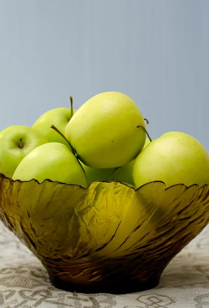 Apel hijau dalam vas kaca di atas kain meja — Stok Foto