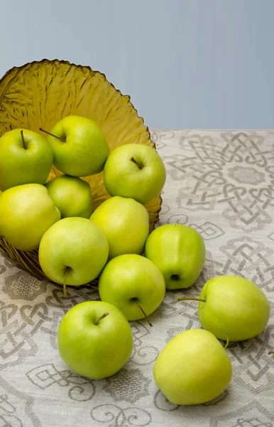 Apel hijau dalam vas kaca di atas kain meja — Stok Foto