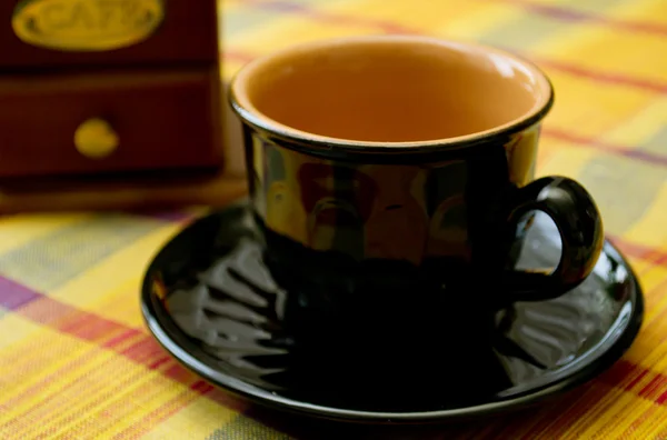 Svarten kuper och kaffekvarn på bordet — Stockfoto