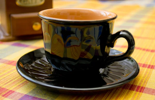 Schwarze Tasse und Kaffeemühle auf dem Tisch — Stockfoto