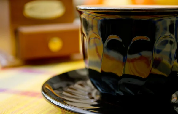 Чорна чашка і кавомолка на столі — стокове фото