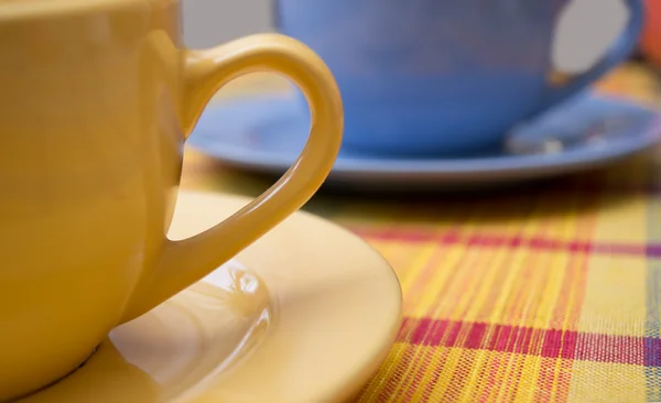 Gelbe und blaue Teetassen auf dem Tisch — Stockfoto