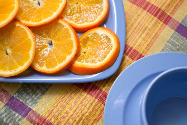 Кусочки апельсина на голубой тарелке — стоковое фото