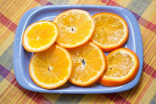 Кусочки апельсина на голубой тарелке — стоковое фото