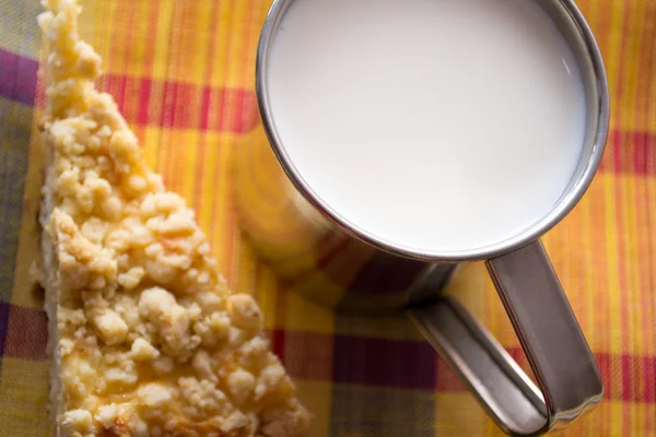 Csésze tej, és egy szelet tortát az asztalon — Stock Fotó
