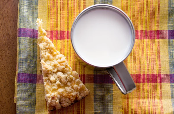Csésze tej, és egy szelet tortát az asztalon — Stock Fotó