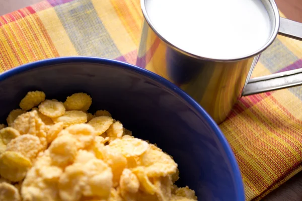 Bowl of cornflakes on the table and a cup of milk — Stock Photo, Image