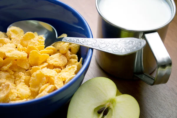 Corn flakes with milk and an apple on the table - Stok İmaj