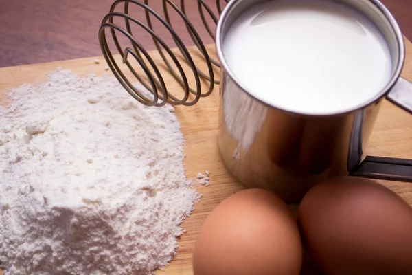 stock image Cup of milk, flour and two eggs