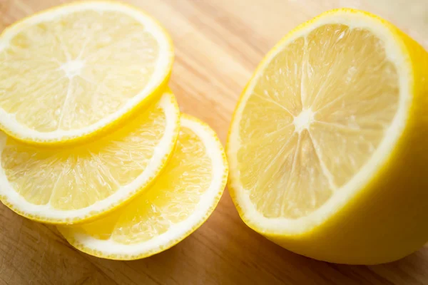 Лимонные ломтики на деревянной доске — стоковое фото