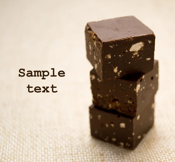 Três cubos de chocolate em um guardanapo de linho Fotografias De Stock Royalty-Free