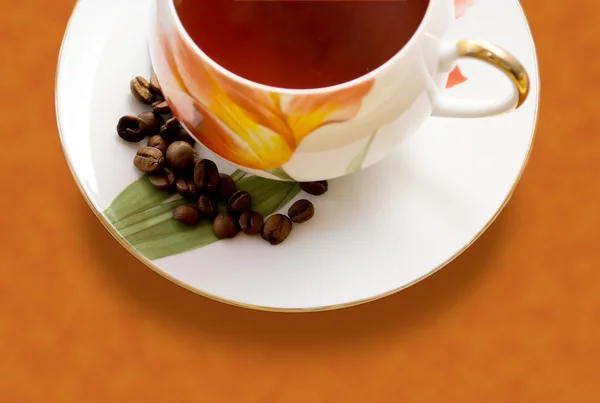 Tasse Kaffee und Kaffeebohnen auf einem Tisch — Stockfoto