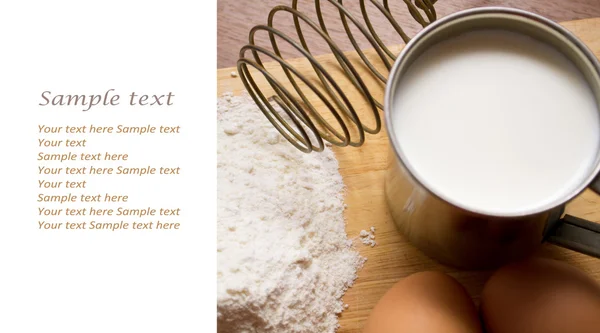 Cup of milk, flour and two eggs — Stock Photo, Image
