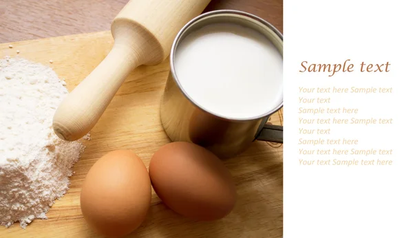 Cup of milk, flour and two eggs — Stock Photo, Image