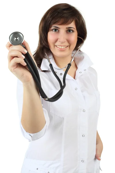 Doctor smiles and holding stethoscope to camera - isolated on wh — Stock Photo, Image