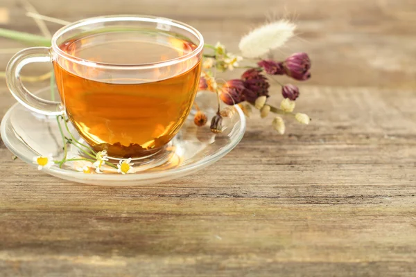 Чай и цветы на деревянном фоне — стоковое фото