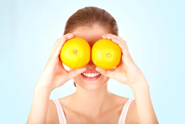 Funny glad tjej tittar med apelsiner — Stockfoto
