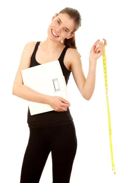 Sporty happy girl holding scales and tape — Stock Photo, Image