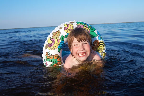 Glückliches Mädchen schwimmt mit Rettungsboje — Stockfoto
