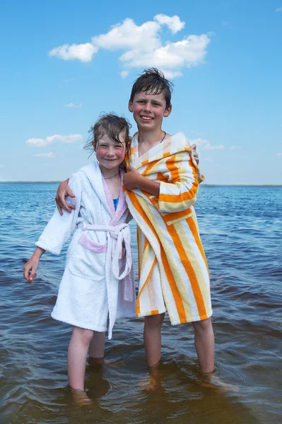 Junge umarmt Mädchen auf See — Stockfoto