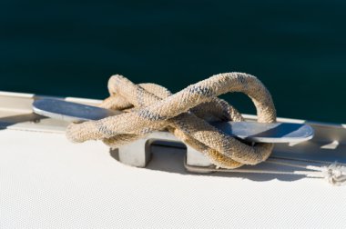 Close up picture of mooring line attached to the sailing yacht cleat clipart