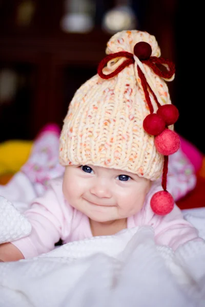 Baby girl in a yellow hat with bobbles — Stock Photo, Image