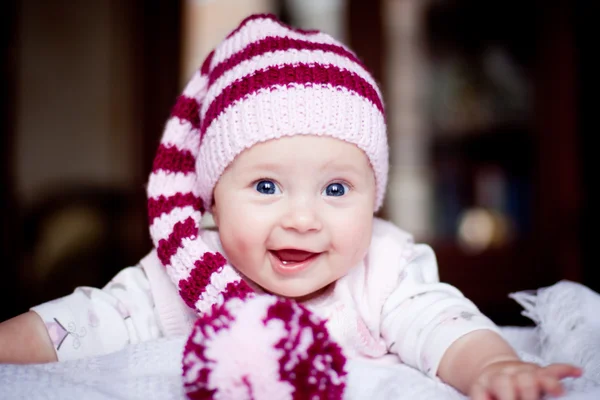 Cute happy baby in a striped hat with bobble — Stock Photo, Image