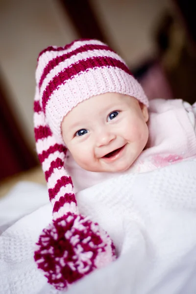 Glimlachende babymeisje in muts met pompom — Stockfoto