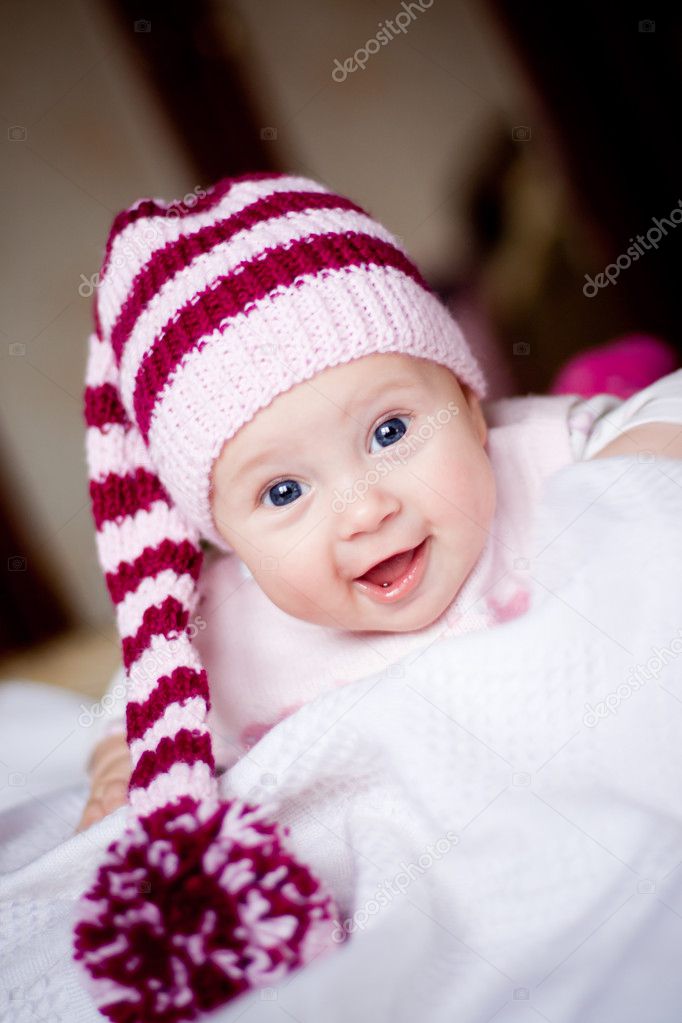 Baby girl in striped hat with pompom
