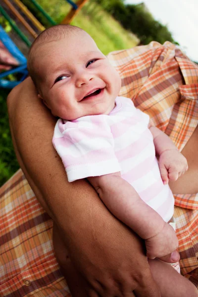 Meisje van de baby in haar vaders handen — Stockfoto