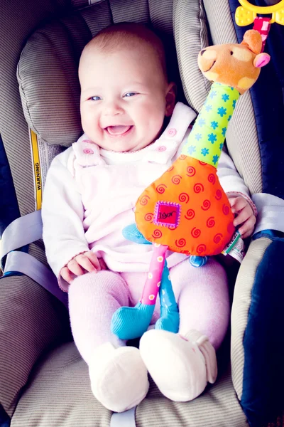 Baby meisje glimlach in autostoel — Stockfoto