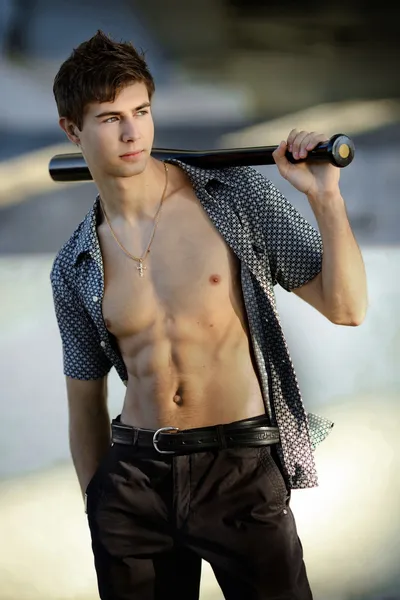 Attraente giovane uomo con una mazza da baseball — Foto Stock