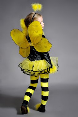 Small girl is dressed at bee costume clipart