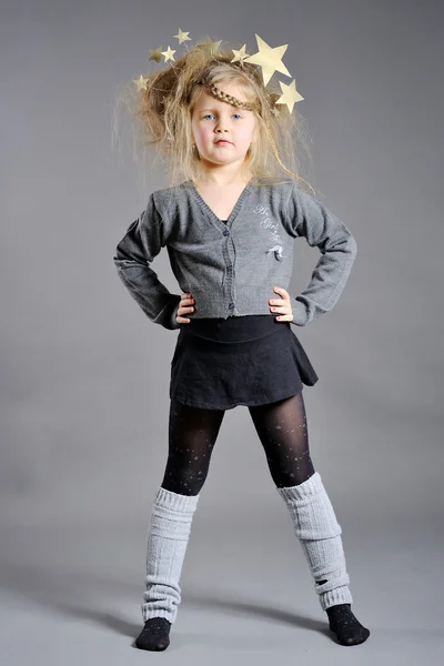 Liten flicka klädd i det nya året på en grå bakgrund — Stockfoto