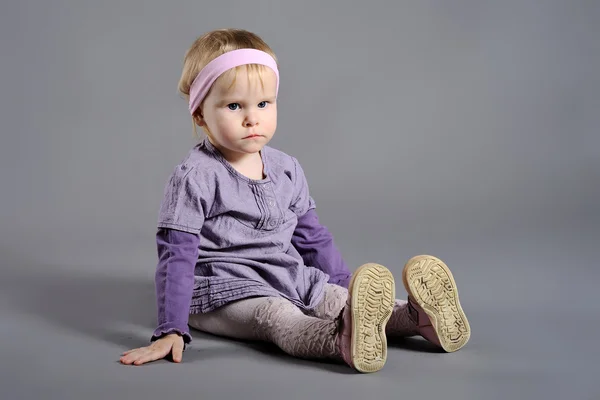 Kleines Mädchen im Studio auf grauem Hintergrund — Stockfoto
