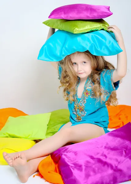 Renkli yastık ile oynayan küçük bir kız portresi — Stok fotoğraf
