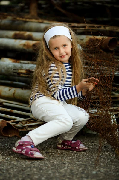 Retrato de uma menina em um aterro de sucata enferrujado metal — Fotografia de Stock