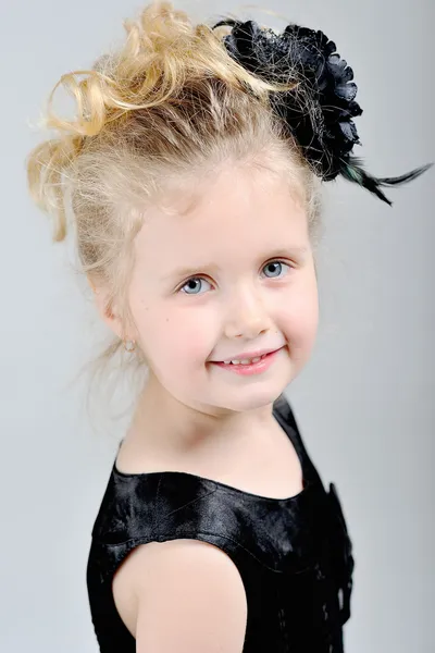 Portret van een klein meisje in een zwarte jurk — Stockfoto