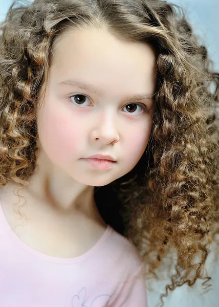 Portrait of a beautiful little girl with curls — Stock Photo, Image
