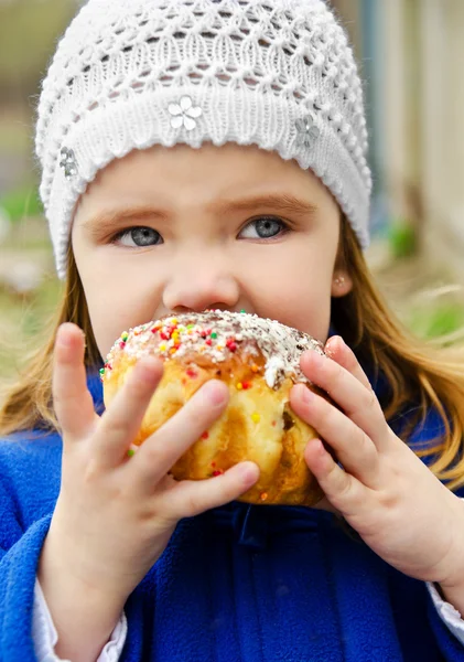 Portrait of little girl eating cake outdoor — Stock Photo, Image
