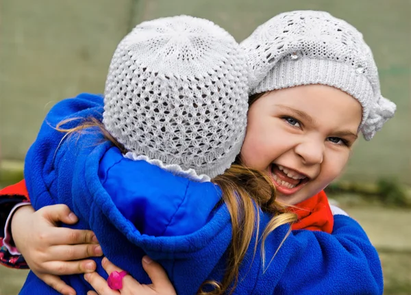 Две маленькие девочки обнимают друг друга — стоковое фото