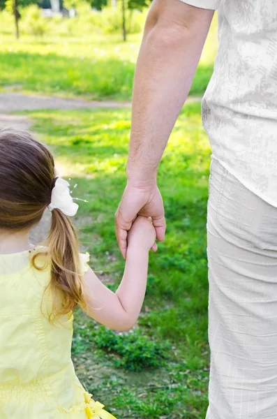 Маленькая девочка держит за руку отца — стоковое фото