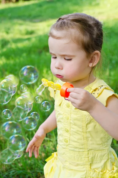 stock image Portrait of little girl blowing soap bubbles