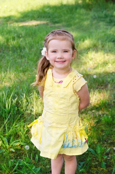 Portræt af smilende lille pige i kjole udendørs - Stock-foto