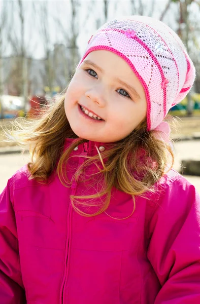 Портрет улыбающейся маленькой девочки на открытом воздухе в весенний день — стоковое фото